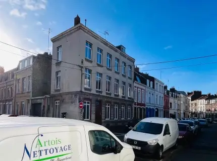 Une camionnette garée devant une rangée de bâtiments.